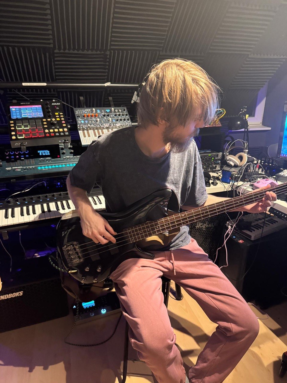 Fabian Burakowski spielt E-Bass vor seinem Synthesizer-Rack